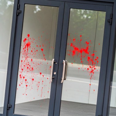 Red paint splashed on glass doors